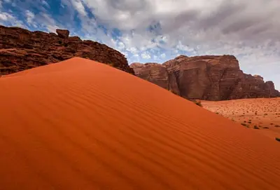 a view of a desert with mountains and a red dune at Golden sunset luxury camp in Wadi Rum