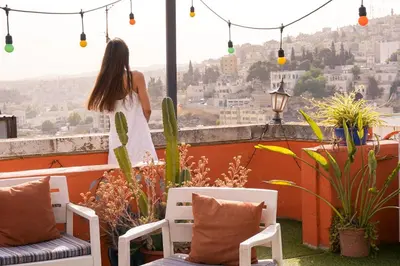 a woman standing on a balcony looking out at the city at Medusa Home Stay in Amman
