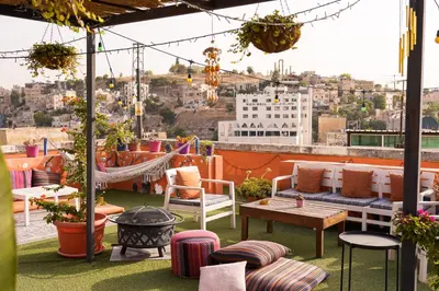 a rooftop patio with furniture and a fire pit at Medusa Home Stay in Amman