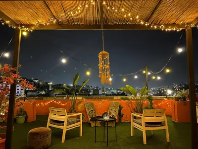 a patio with chairs and a table and lights at Medusa Home Stay in Amman