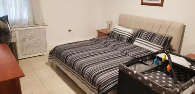 a bedroom with a bed with a black and white blanket at Charming Apartment in Shmeisani in Amman