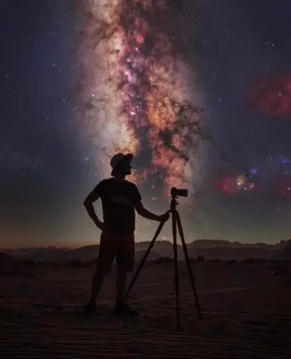a man standing next to a telescope in the desert at Wadi rum Rozana camp in Wadi Rum