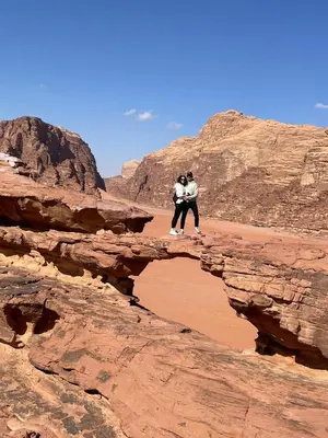 two people standing on a rock in the desert at Wadi rum Rozana camp in Wadi Rum