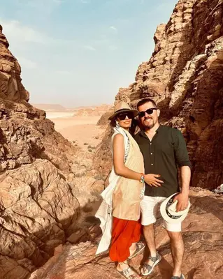 a man and woman posing for a picture in the desert at Wadi rum Rozana camp in Wadi Rum