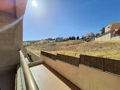a concrete wall with a walkway next to a hill at Abdoun Panorama in Amman
