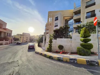 a street with a car parked next to a building at Abdoun Panorama in Amman