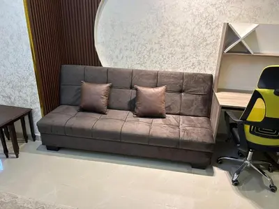 a couch with two pillows on it in a room at Shafa Badran Families Apt in Amman