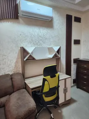 a desk and a chair in a room with a computer at Shafa Badran Families Apt in Amman