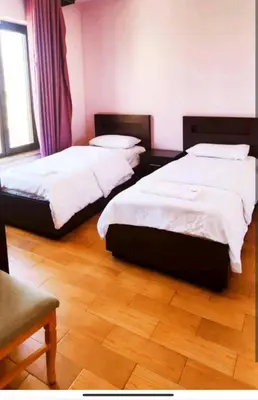 two beds in a bedroom with a wooden floor at Seven stars hotel apartment in Amman
