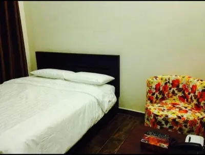 a hotel room with a bed and a chair at Seven stars hotel apartment in Amman