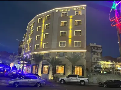 a hotel with cars parked in front of it at night at Yafko Hotel in Aqaba