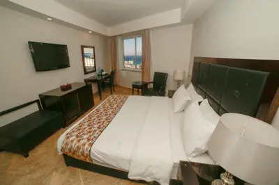 a hotel room with a large bed and a desk at Yafko Hotel in Aqaba