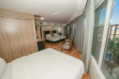 a bedroom with a bed and a living room at Yafko Hotel in Aqaba