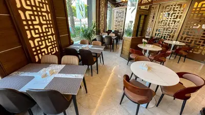 a restaurant with tables and chairs in a room at Yafko Hotel in Aqaba