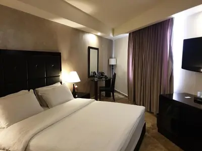 a hotel room with a large bed and a desk at Yafko Hotel in Aqaba