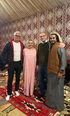 a group of three men and a woman standing on a rug at Rum Under The Stars Camp in Wadi Rum
