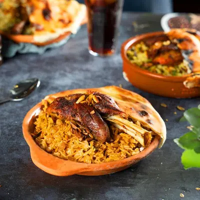 a bowl of food with a sausage and rice at Al Joude Hotel فندق الجود in Irbid