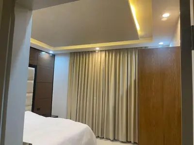 a bedroom with a bed and a curtain at Oqdeh Delux Apartments in Jerash