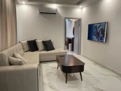 a living room with a couch and a table at Oqdeh Delux Apartments in Jerash