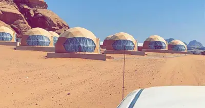 a row of domes in the middle of the desert at Armony rum camp in Wadi Rum
