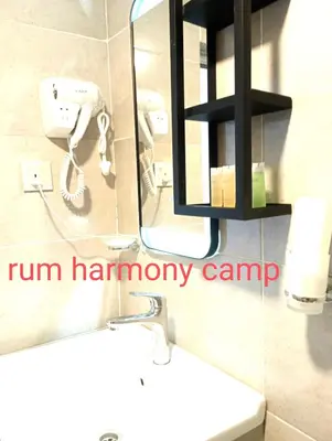 a bathroom with a sink and a phone on the wall at Armony rum camp in Wadi Rum