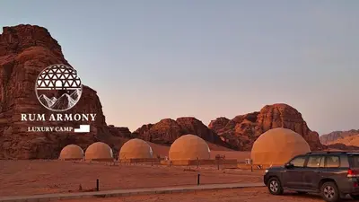 a suv parked in front of a building in the desert at Armony rum camp in Wadi Rum
