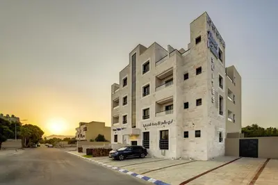 a building with a car parked in front of it at Three Palms Suites in Aqaba