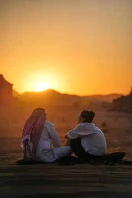 two people sitting in the desert watching the sunset at Desert's Soul Wadi Rum in Disah