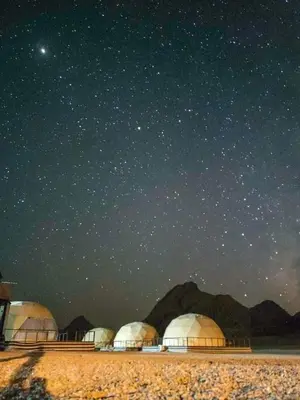 a group of domes under a night sky with stars at Sami Al Muzna Rum Camp in Wadi Rum