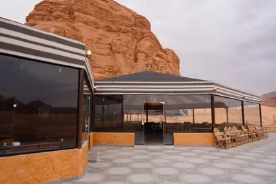 a building in the desert with a view of a mountain at Mirage Camp Wadi Rum in Wadi Rum