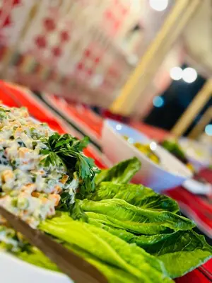 a plate of food on a table with salad and greens at Mirage Camp Wadi Rum in Wadi Rum