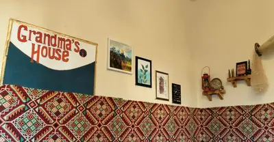 a room with a banner on the wall with pictures at Grandma's house in Wadi Musa