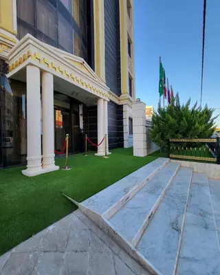 a building with a green lawn in front of it at Pretal Hotel in Al Mafraq