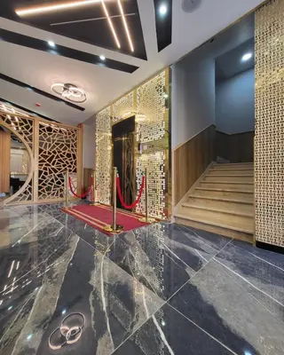 a lobby with a red carpet and a staircase at Pretal Hotel in Al Mafraq