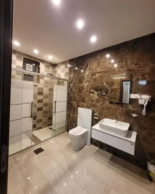 a bathroom with a toilet and a sink and a shower at Pretal Hotel in Al Mafraq