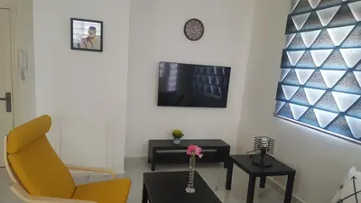 a living room with a yellow chair and a table at Shmeisani homes central location near Abdali in Amman