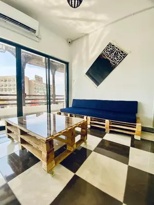 a living room with a blue couch and a table at Friends Oasis in Aqaba