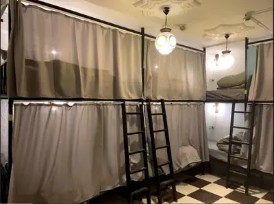 a group of bunk beds in a room with curtains at Friends Oasis in Aqaba