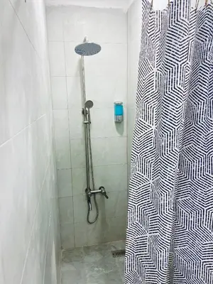 a shower with a black and white shower curtain in a bathroom at Friends Oasis in Aqaba