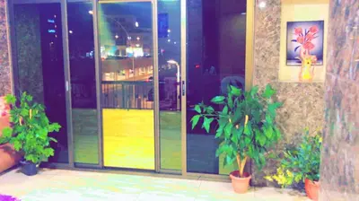 a glass door of a building with potted plants at Amir Palace Hotel in Aqaba
