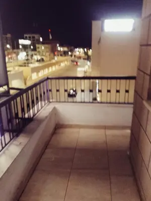 a balcony of a building at night with a street at Amir Palace Hotel in Aqaba