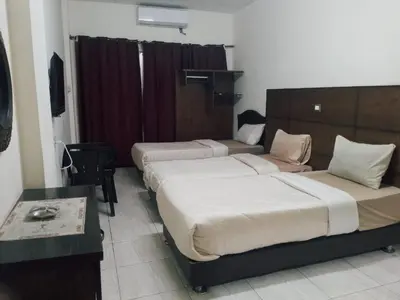 a hotel room with two beds and a table at Amir Palace Hotel in Aqaba