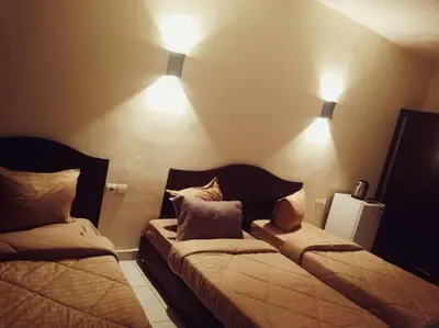 two beds in a room with lights on the wall at Amir Palace Hotel in Aqaba