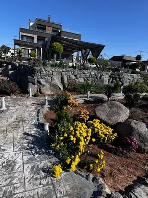 a garden with yellow flowers in front of a house at Kinda vip in Al Mashāriqah