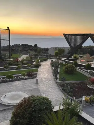 a view of a garden with a sunset in the background at Kinda vip in Al Mashāriqah