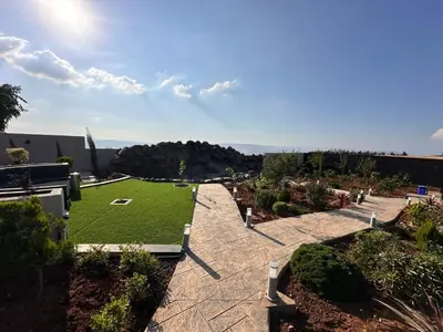 a garden with green grass and a patio at Kinda vip in Al Mashāriqah