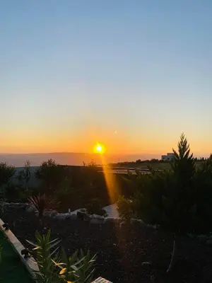 a sunset with the sun setting over the ocean at Kinda vip in Al Mashāriqah