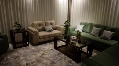 a living room with a green couch and a chair at Kinda vip in Al Mashāriqah