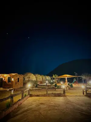 a group of buildings at night with lights at Bilal luxury camp in Wadi Rum