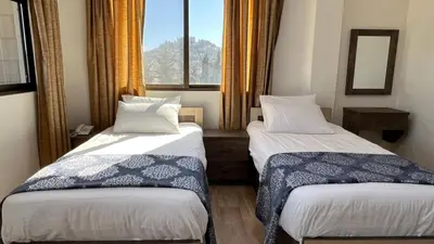 two beds in a room with a window at Al-jabal castle Hotel - Ajloun in Ajloun